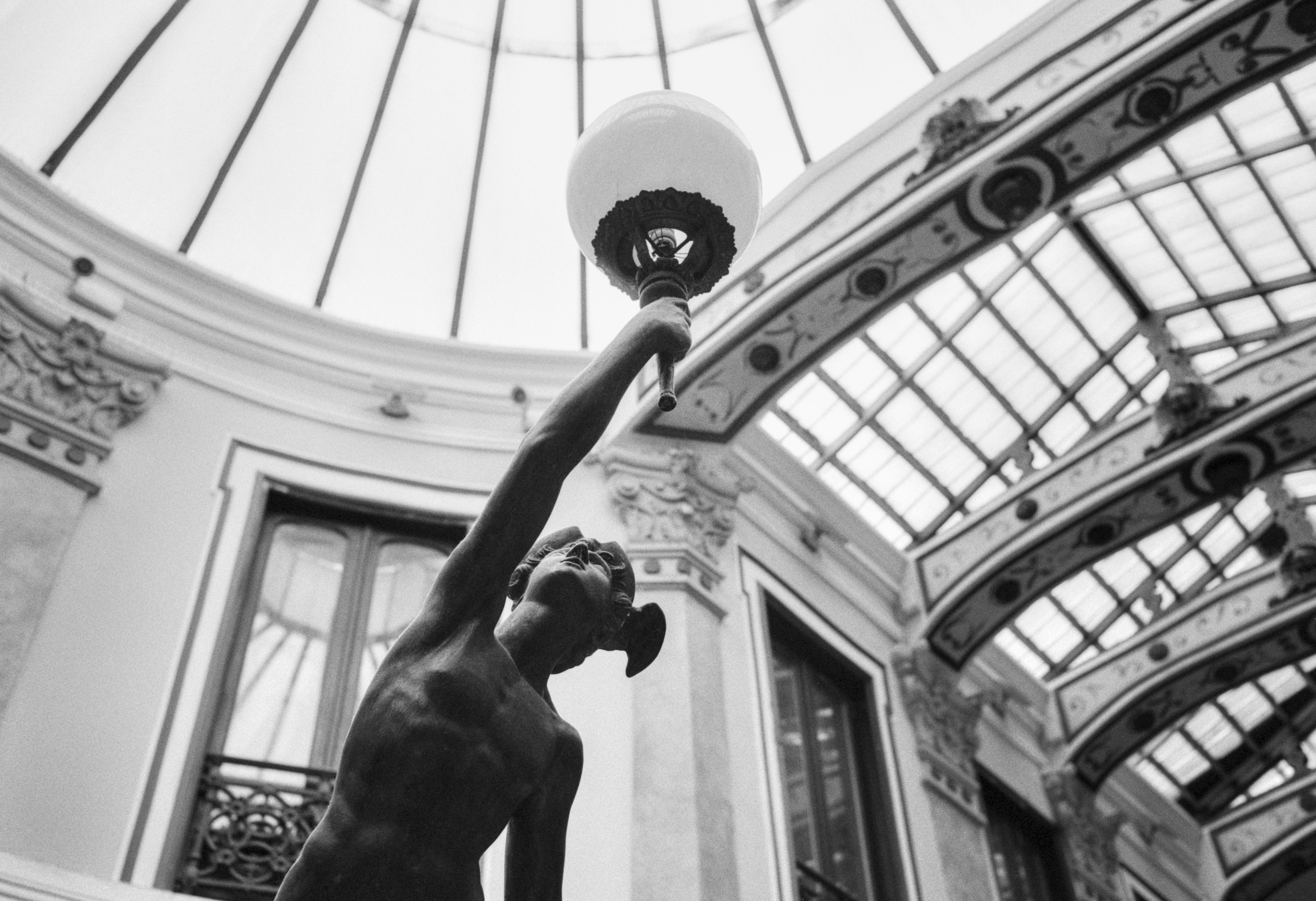 Statue of Mercury holding a lamp inside the historic Pasaje Gutiérrez in Valladolid.