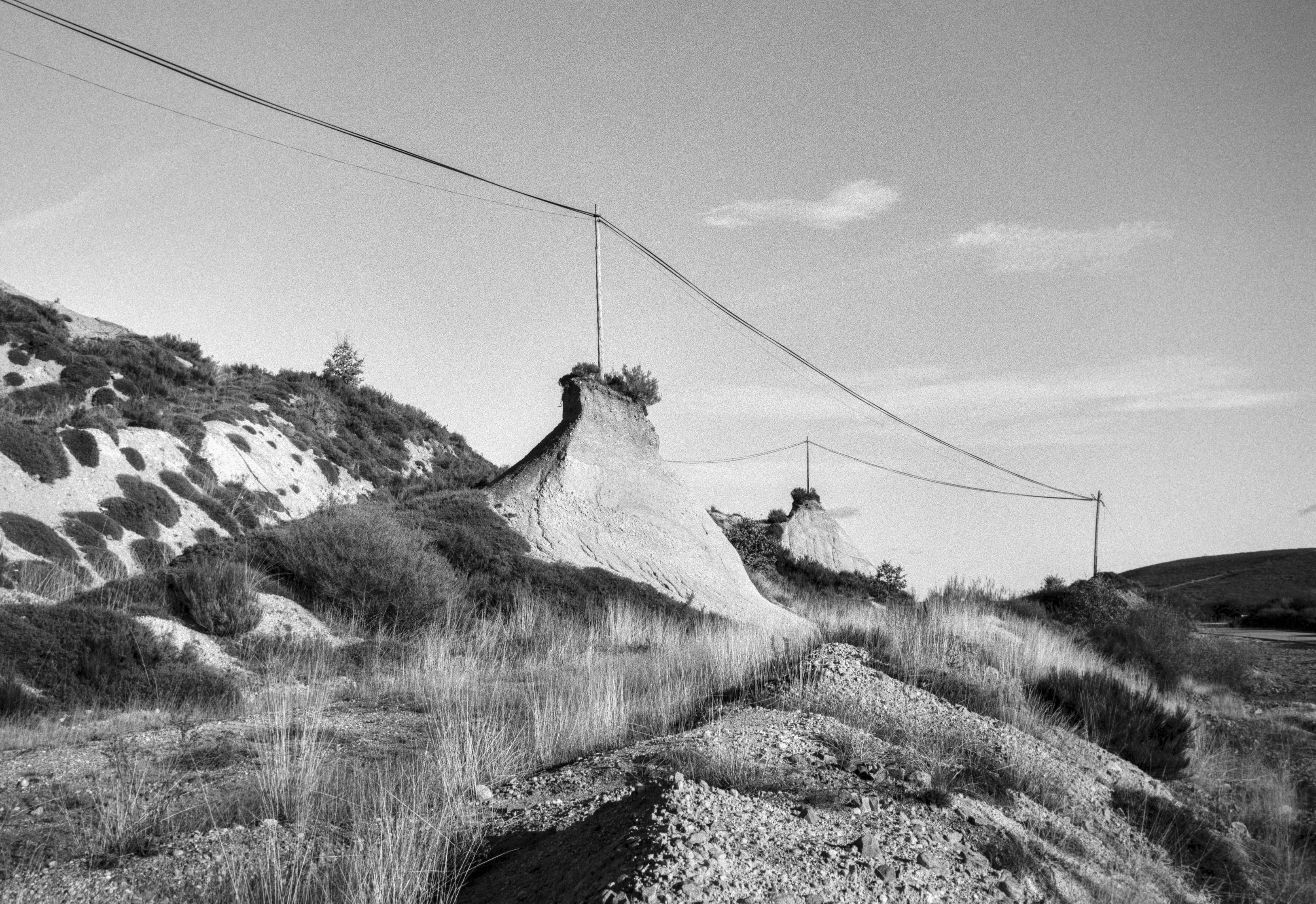 Eroded hills with an elevated power line crossing the landscape near Soto y Amío.